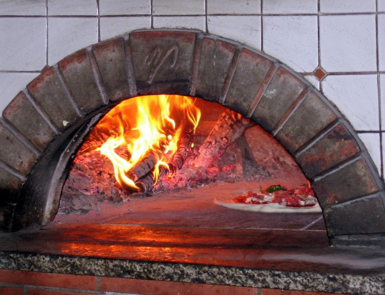 Brick pizza oven with pizza inside